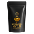 Black tea packaging with gold elephant design and 'Riverbeki Gold Assam Tea' text on a white background
