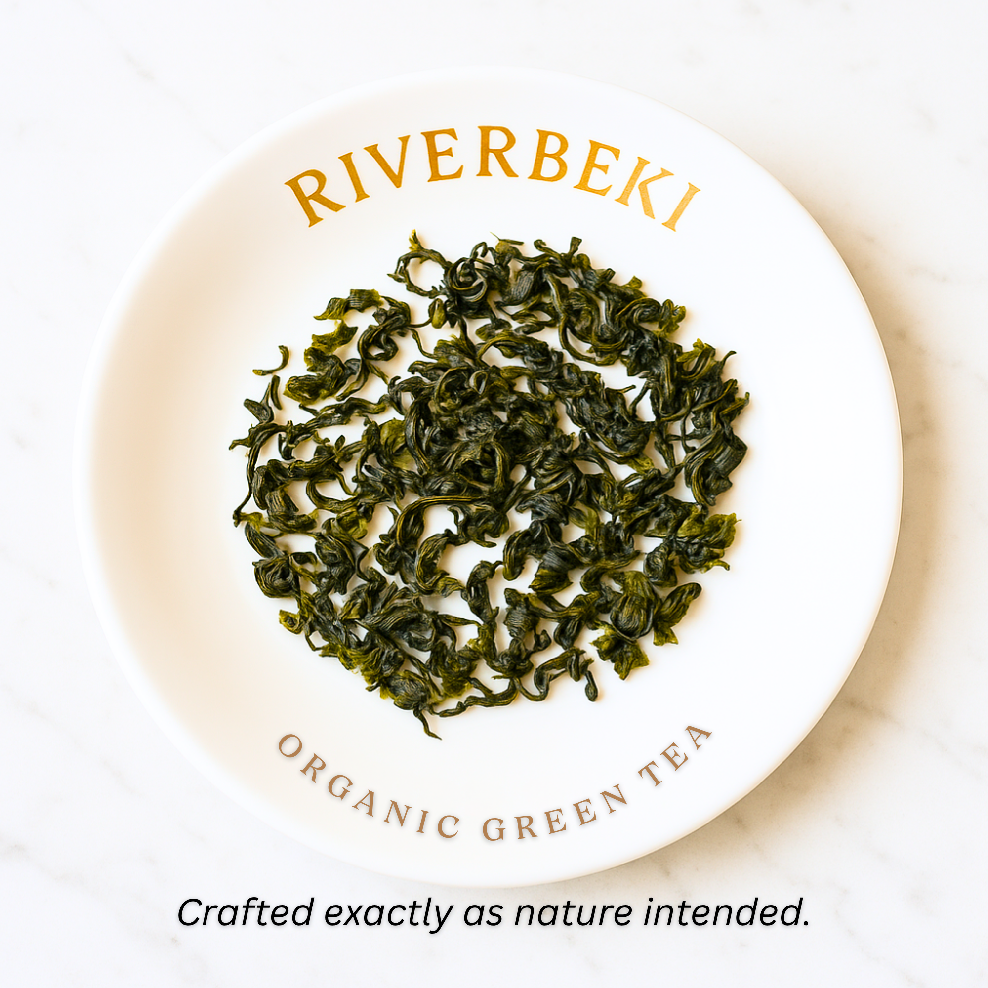 Organic green tea leaves on a white plate with 'Riverbeki' branding.